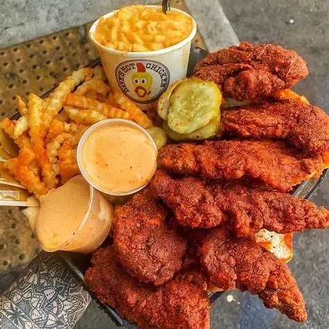 Spicy chicken sandwich and crinkle-cut fries promoting Dave's Hot Chicken discount code